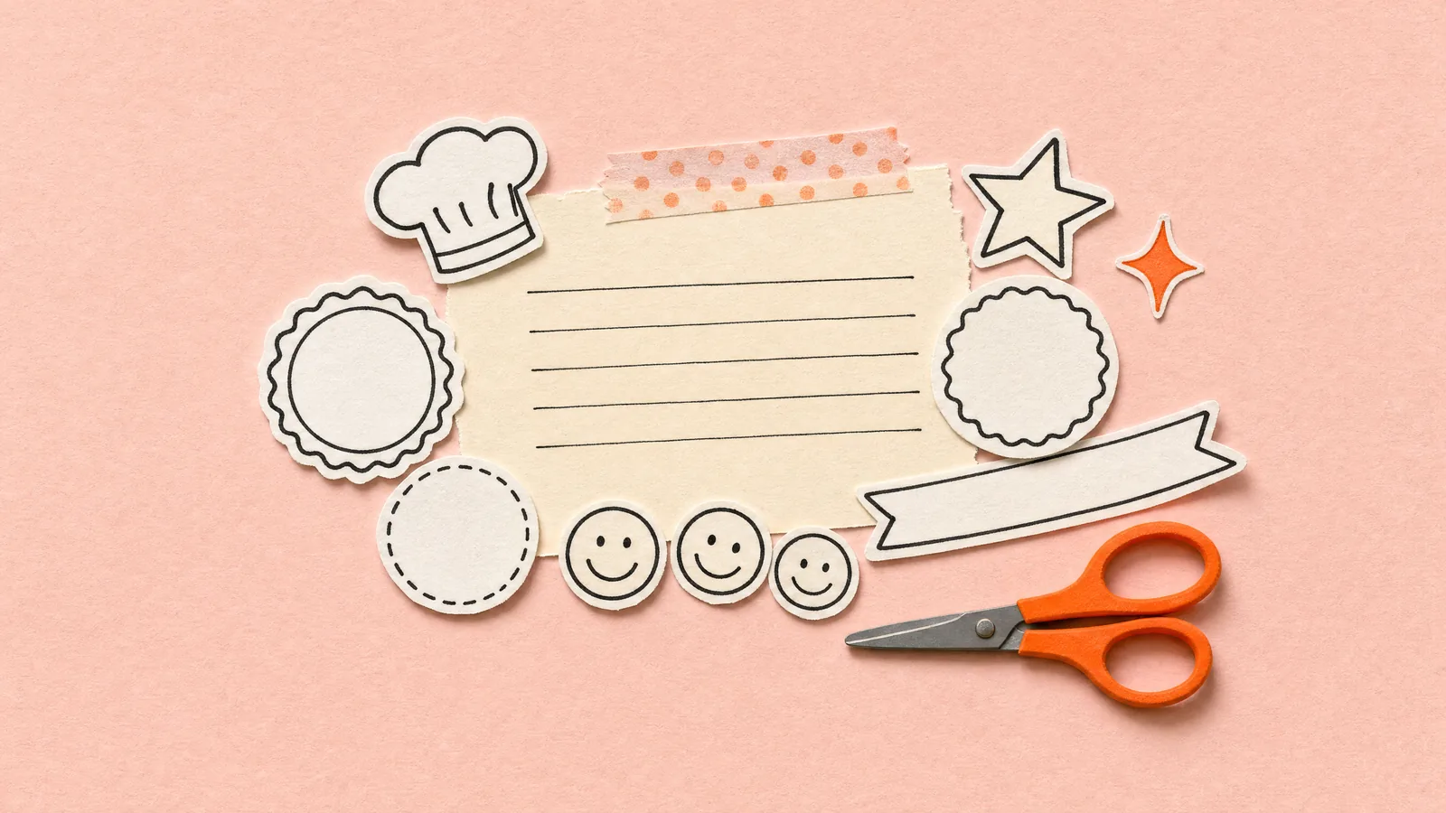 A ruled cream sheet with paper cut-outs spilling from it: a chef's hat, round badges, smiley stickers, a star and a banner strip, with orange scissors, on blush paper.